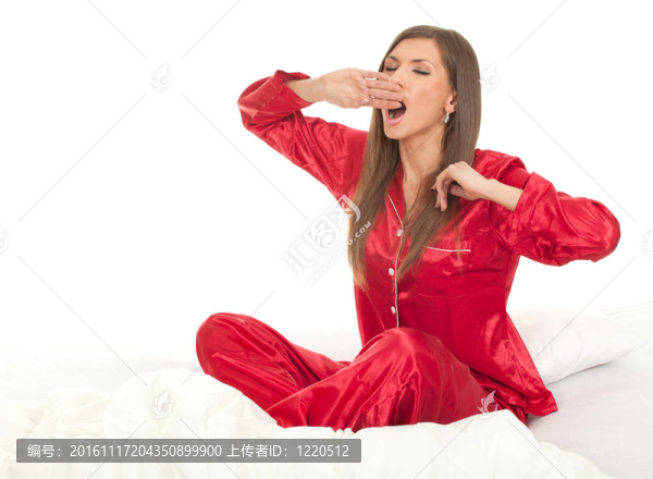 打哈欠的美麗年輕女子睡在白色被褥；系列