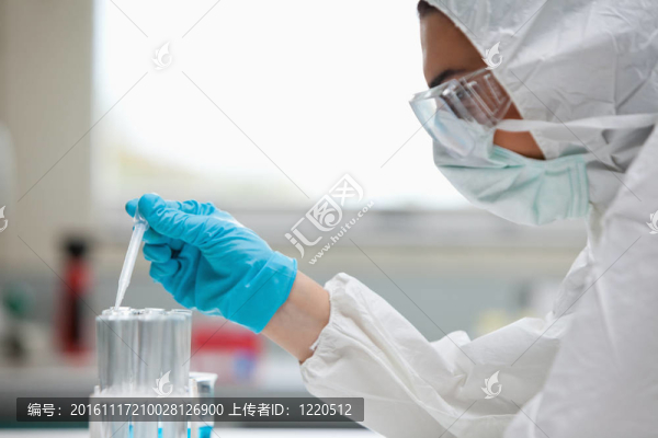 一個受保護的女科學(xué)家在實驗室的試管中滴液的特寫