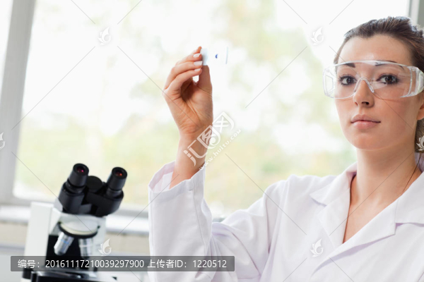 美麗的理科學(xué)生拿著顯微鏡幻燈片