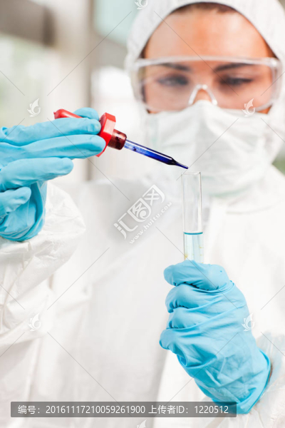 實驗室中一個受保護的科學家在試管中滴下液體的肖像