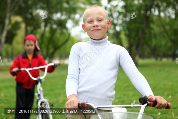 在綠色公園里騎自行車的男孩