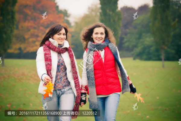 兩個(gè)年輕的女人走在秋天的公園