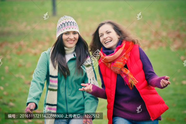 兩個(gè)年輕的女人走在秋天的公園