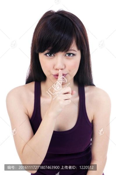 可愛的年輕女子手指在嘴唇上
