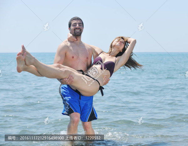 快樂的年輕情侶在海灘上度過浪漫時光