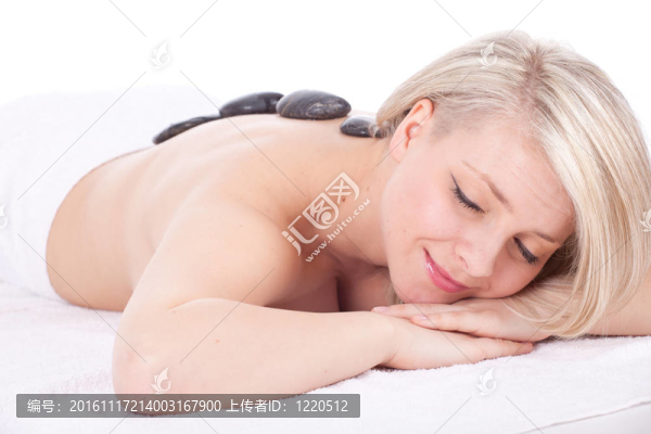 美麗的年輕女子在水療院；石頭按摩