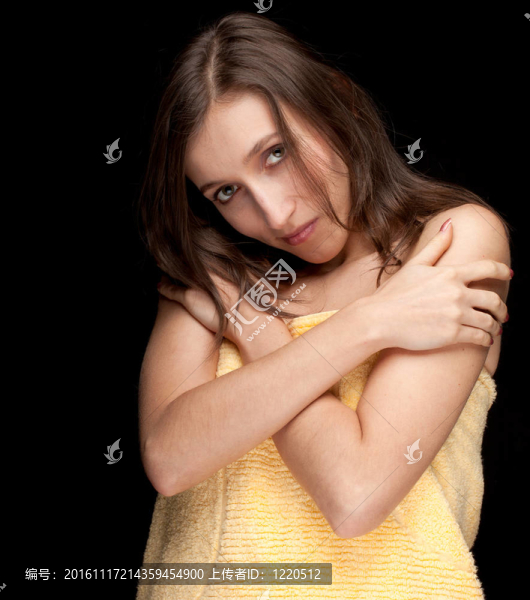 漂亮的年輕長(zhǎng)發(fā)女人在黃色毛巾；黑色背景