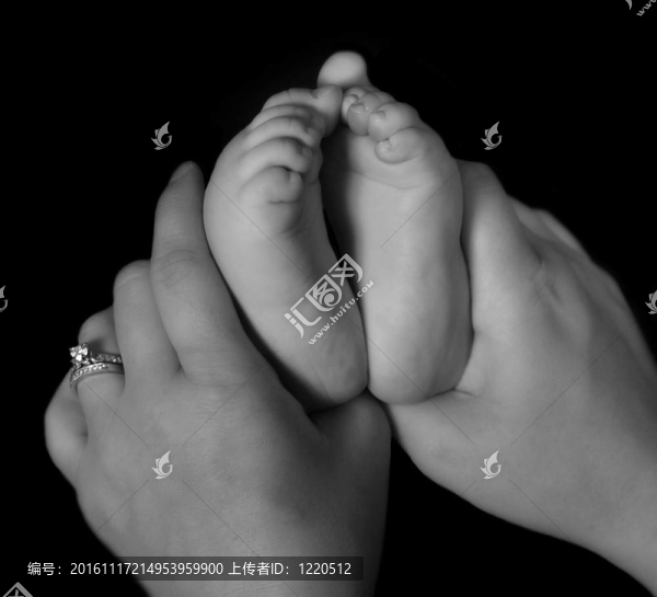母親雙手抱著黑色和白色的嬰兒腳特寫(xiě)。孤立的黑色