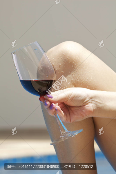 泳池派對。女子拿著一杯酒。