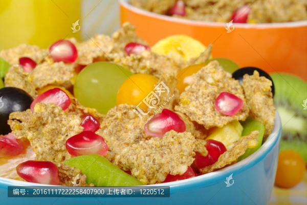 以彩色橙汁為背景的彩色碗中的水果和麥片