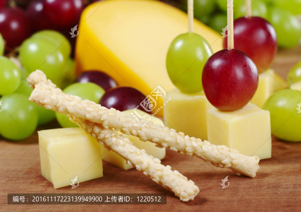 芝麻奶酪和紅葡萄和白葡萄在木板（選擇性的重點；重點在上芝麻棒）