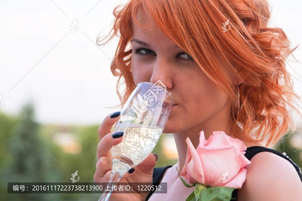 美麗的女人與粉紅玫瑰飲用香檳酒杯