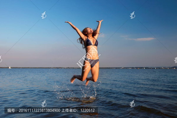 天空和水背景的年輕女子