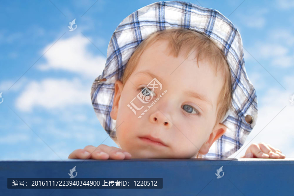 悲傷的可愛小男孩在帽子在天空背景