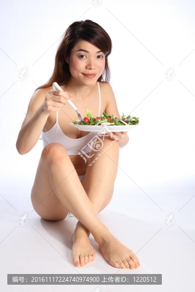 美麗的東方女孩吃沙拉
