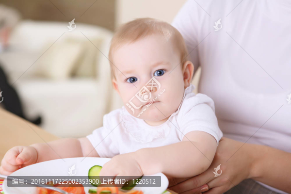 一個年輕的母親在家里喂她的嬰兒