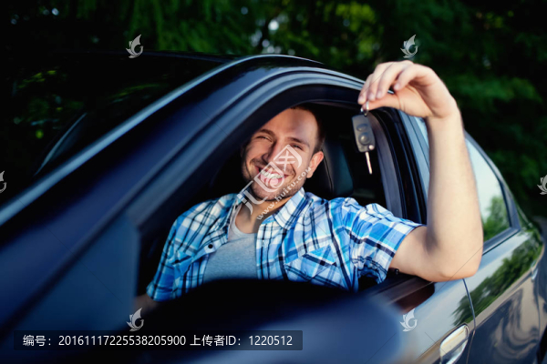 年輕人帶著新車微笑的鑰匙