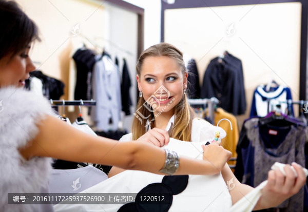 年輕的女人在一家商店買衣服