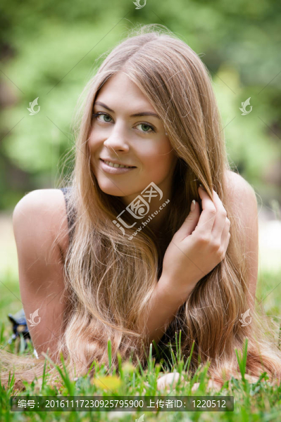 美麗的年輕女人躺在草地上