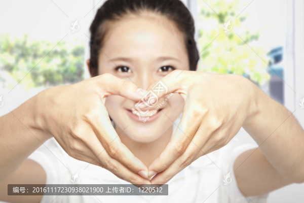 微笑的年輕女子使心形狀