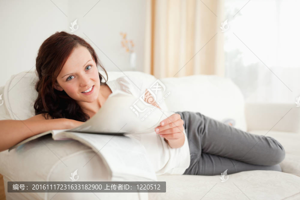 年輕女子在沙發(fā)上學(xué)習(xí)看相機