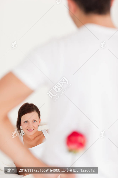 男人藏起了一朵玫瑰花從他的女朋友