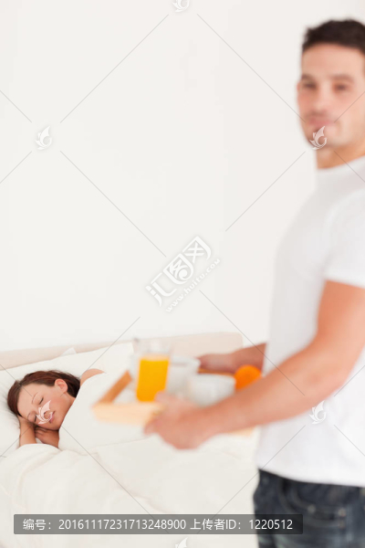 英俊的男人給他熟睡的妻子帶早餐