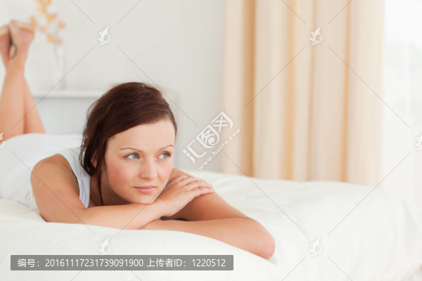 美麗輕松的女人在她的床上