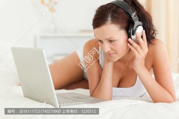女人聽(tīng)音樂(lè)在筆記本電腦上工作