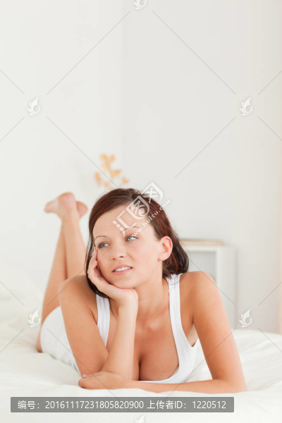 可愛的放松的女人在她的床上