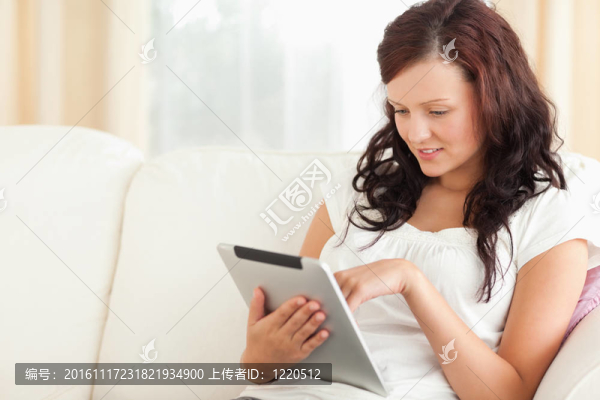 女人，在沙發(fā)上放著一張平板電腦