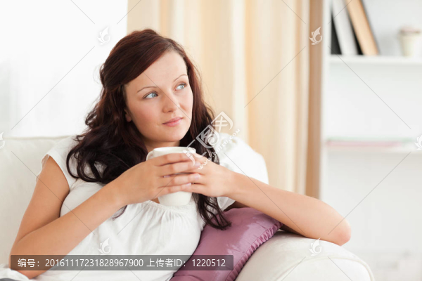 一個(gè)女人拿著杯子看著窗外的畫像