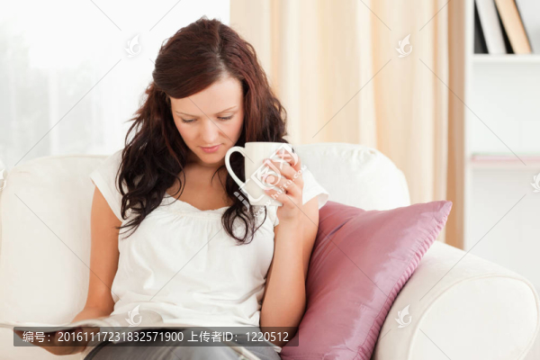 在看雜志的時候拿著杯子的女人