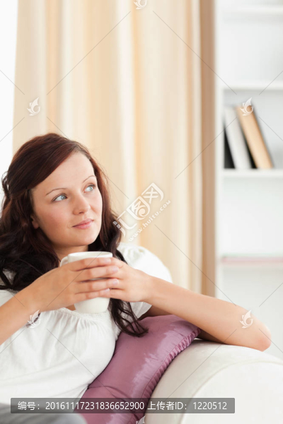 拿著杯子看窗外的女人