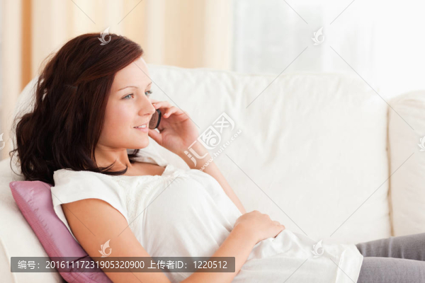 坐在沙發(fā)上打電話的女人