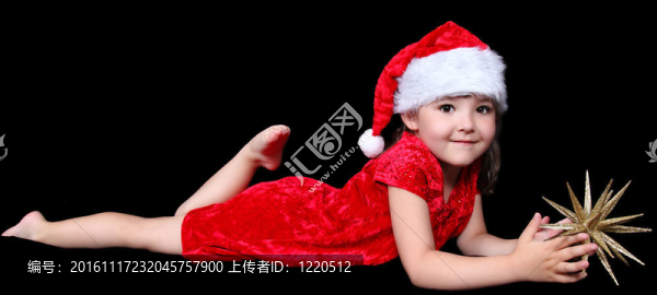 可愛的小女孩在圣誕老人在地板上鋪設(shè)金色圣誕星。孤立的黑色