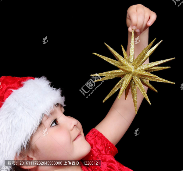 小女孩在圣誕老人戴金色圣誕星特寫鏡頭。孤立的黑色