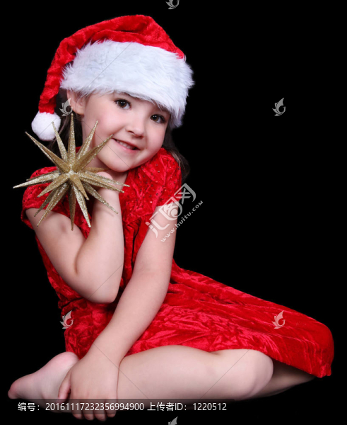 漂亮的小女孩在Santa戴著金色的帽子。孤立的黑色