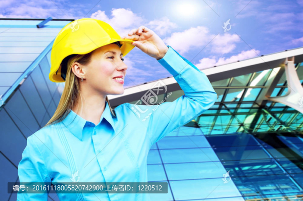 站在建筑物背景上的年輕建筑師女士戴著防護(hù)頭盔