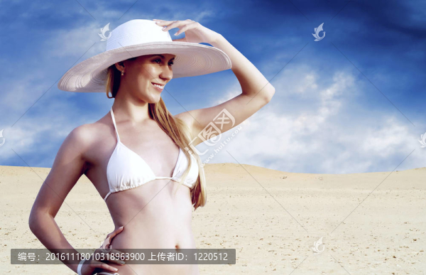 在whitebikini和帽子的年輕漂亮的女人；在陽光明媚的沙漠松弛