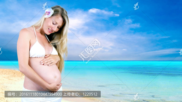 幸福的孕婦在陽光明媚的熱帶沙灘上