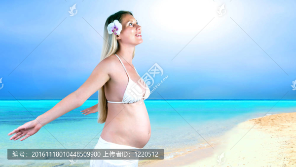 幸福的孕婦在陽(yáng)光明媚的熱帶沙灘上