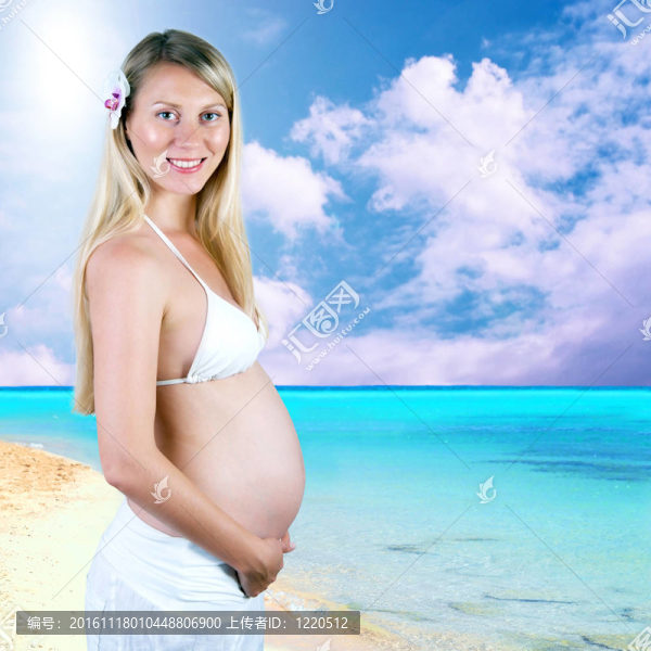 幸福的孕婦在陽光明媚的熱帶沙灘上