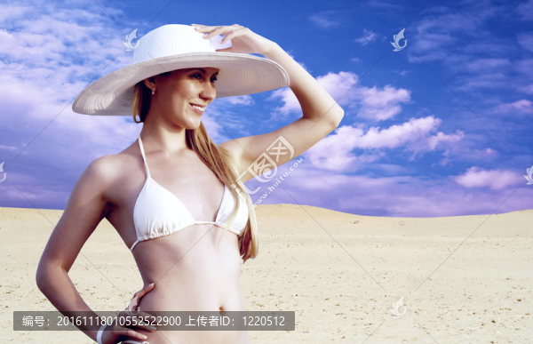 在whitebikini和帽子的年輕漂亮的女人；在陽光明媚的沙漠松弛