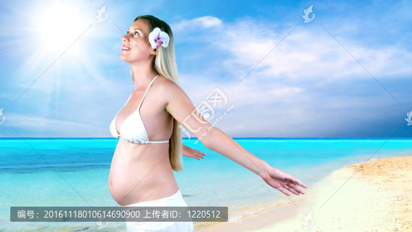 幸福的孕婦在陽光明媚的熱帶沙灘上
