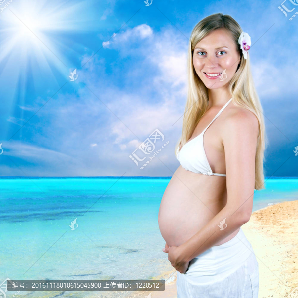 幸福的孕婦在陽(yáng)光明媚的熱帶沙灘上