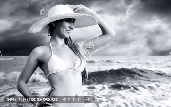 在比基尼和白帽子在陽光明媚的熱帶海灘的年輕漂亮的女人