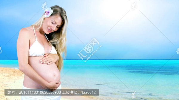 幸福的孕婦在陽光明媚的熱帶沙灘上
