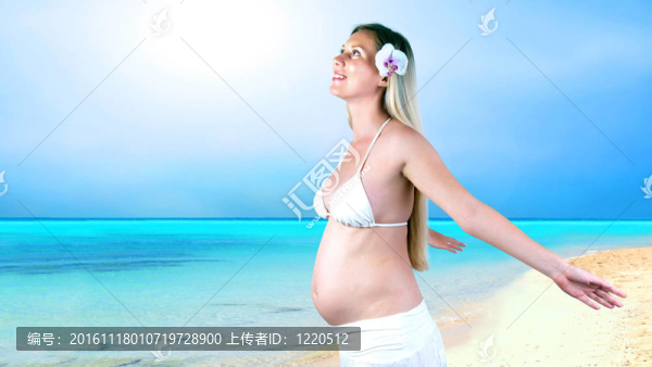 幸福的孕婦在陽光明媚的熱帶沙灘上
