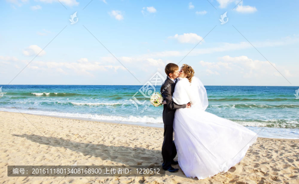 新婚夫婦在海灘上接吻。
